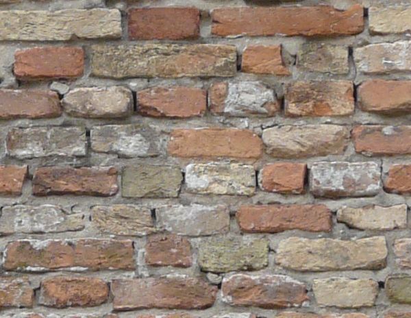 Brick fence texture made up of eroded red and grey bricks, with large mortar gaps in between them. A row of uniformly patterned bricks line the top.